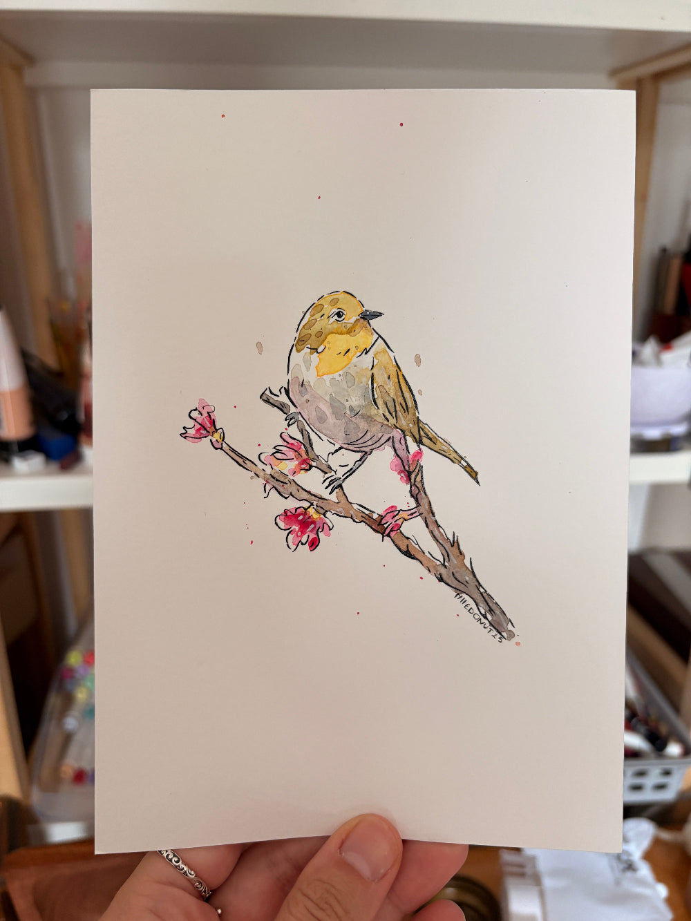 Dessin d'un oiseau jaune beige et gris sur une branche avec des fleurs roses