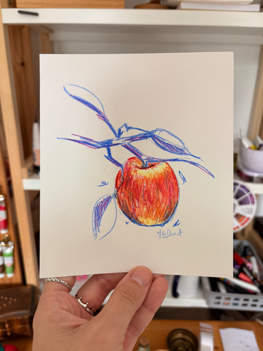 Dessin d'une pomme aux crayons de couleur branches bleus